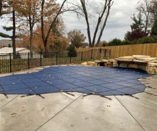 winter pool cover installed to protect pool with curved edges