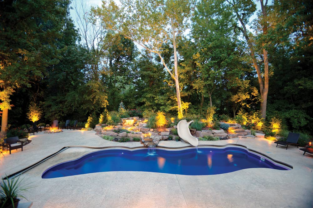 backyard with firepit, pool, water slide, and boulder landscaping