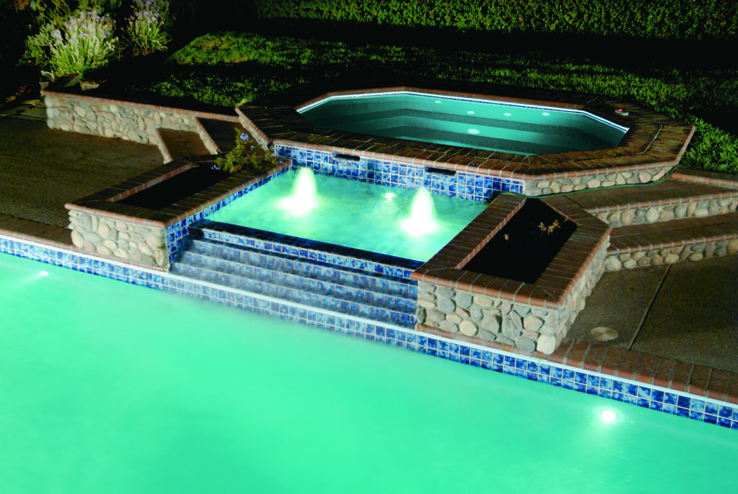 Fiberglass swimming pool with spill over lighting and bubblers