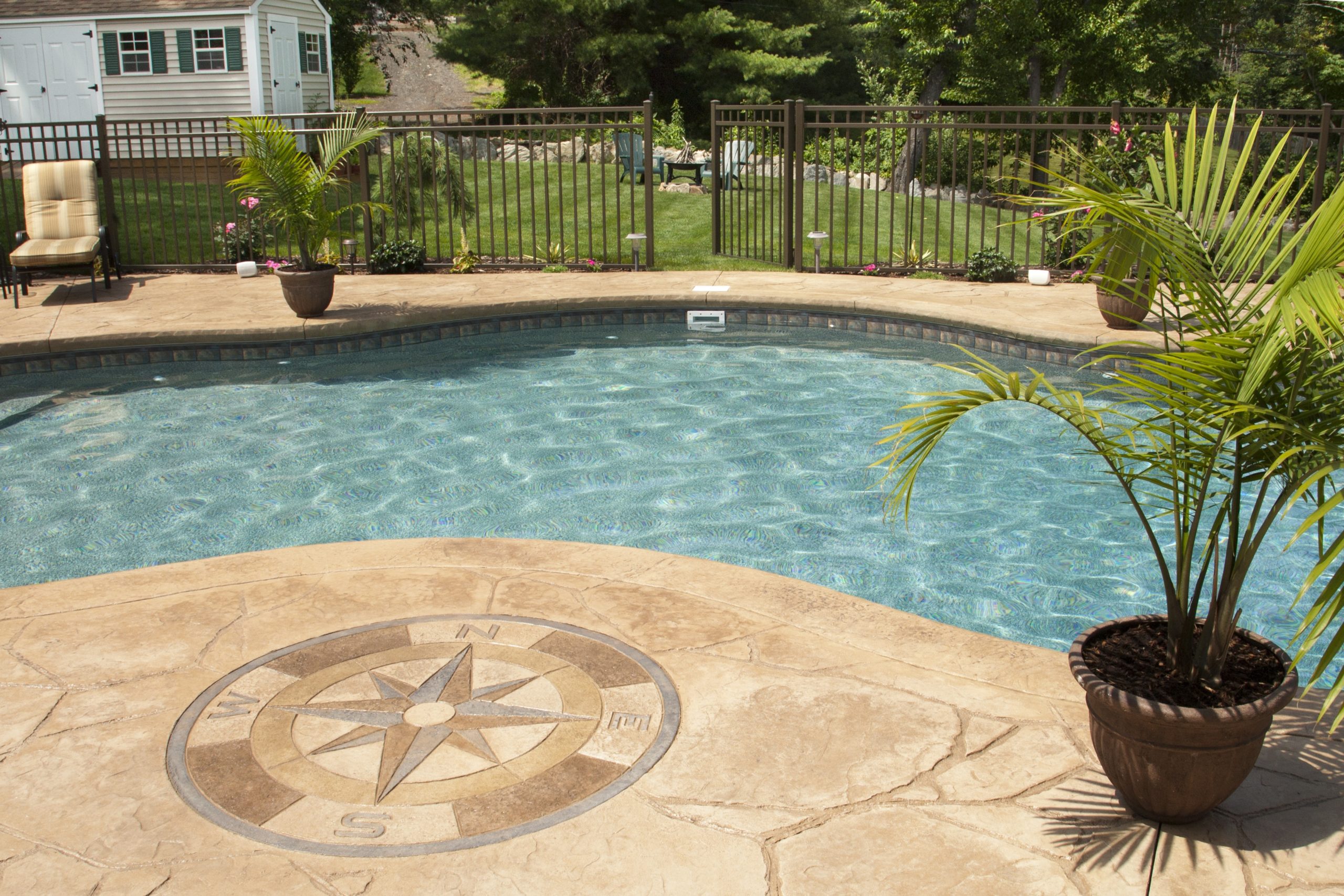 concrete deck with compass at a freeform poolside