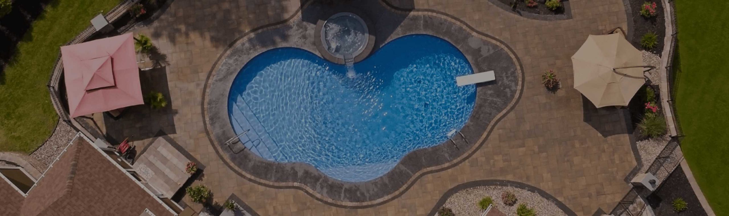 A bird's-eye view of a refreshing inground pool surrounded by a landscaped backyard.