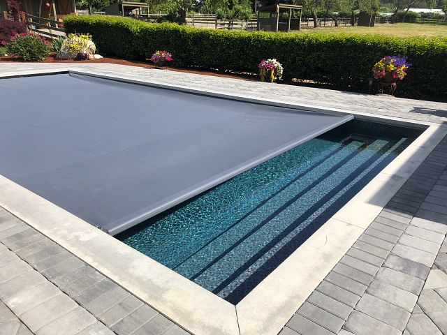 Vinyl liner pool with under track automatic safety cover in gray