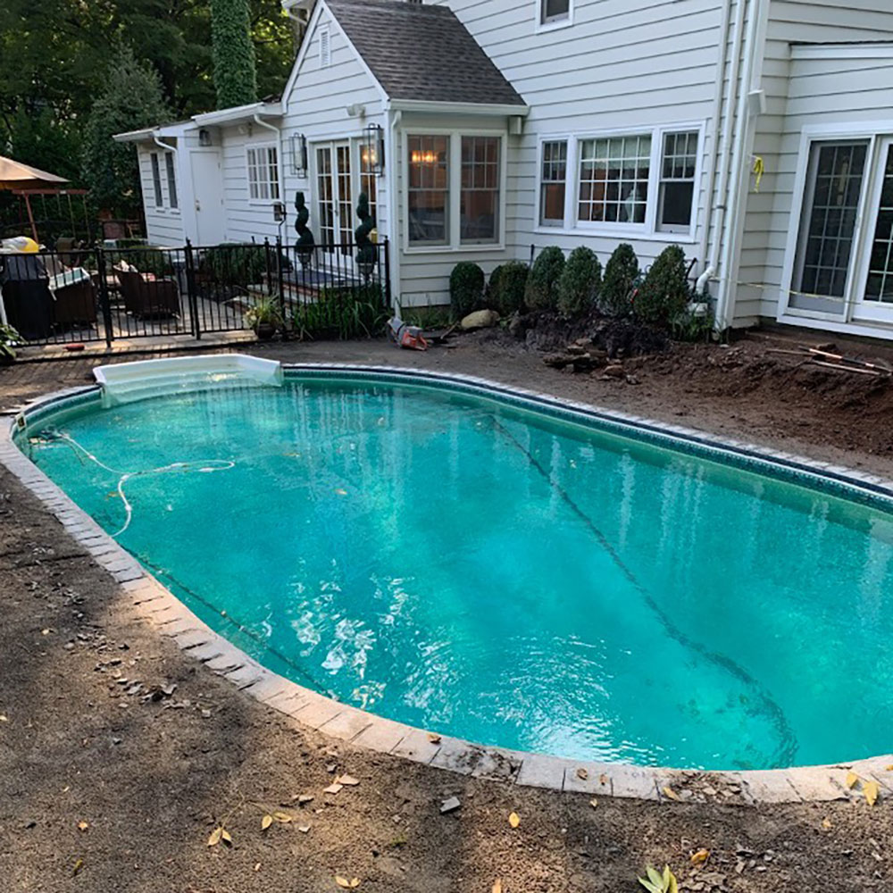 Oval vinyl liner pool with dirt surrounding it