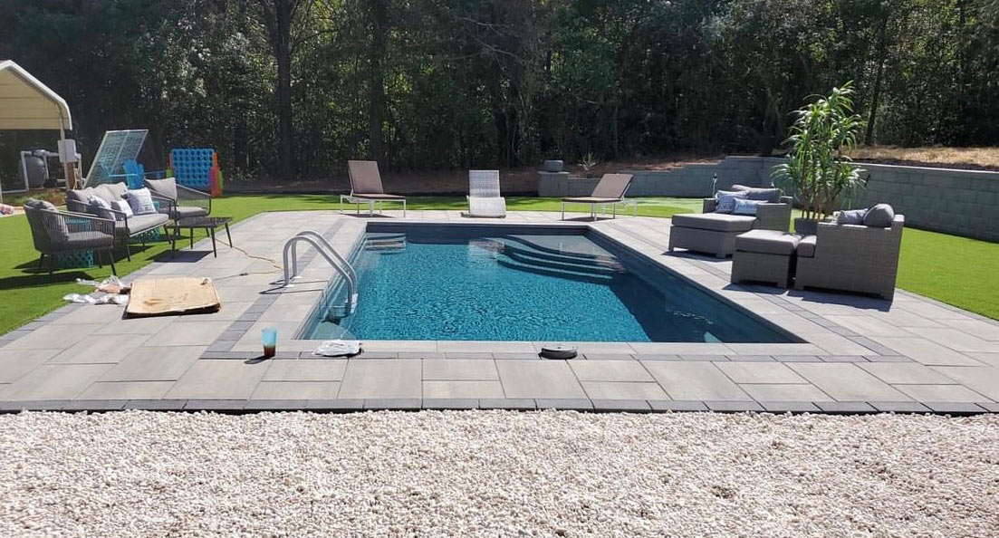 rectangular fiberglass pool and deck furniture in a North Carolina backyard