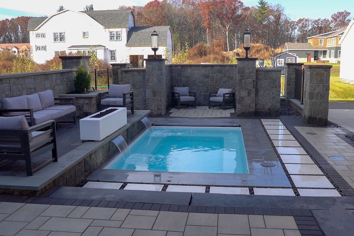 Latham rectangular pool and water fall element with patio and deck furniture