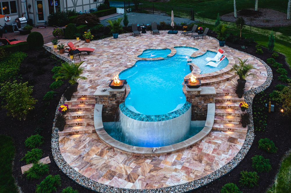 Pennsylvania fiberglass pool with tanning ledge, fire pits, and custom waterfall