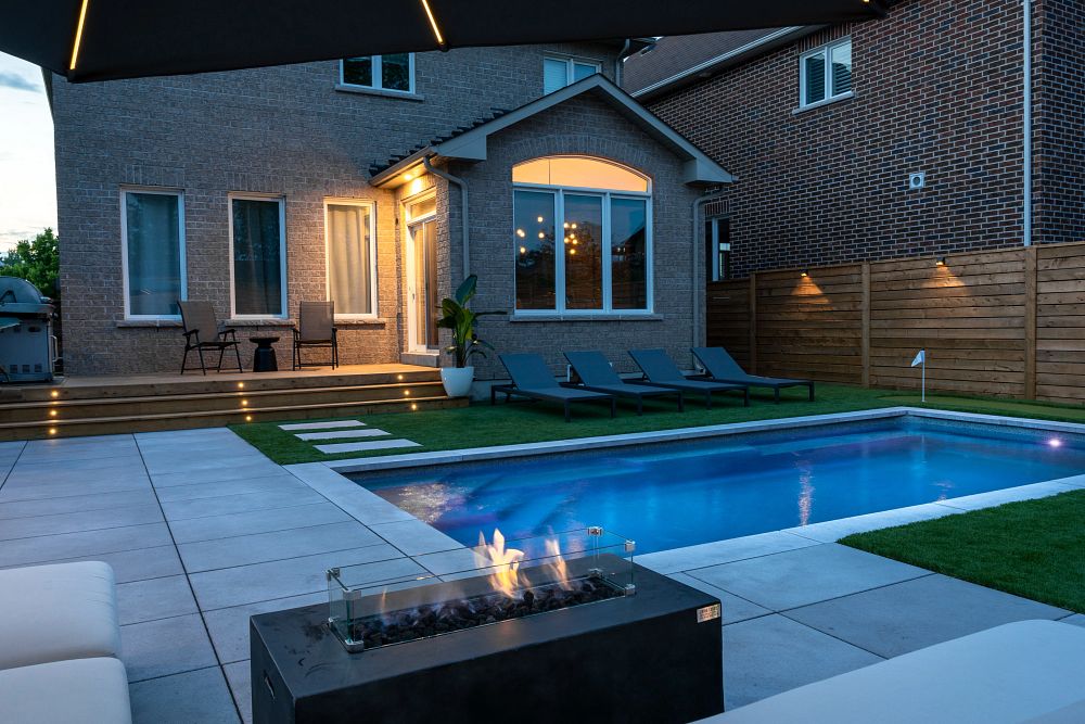 low budget backyard pool ideas with small rectangular pool and deck with patio furniture and a fire pit