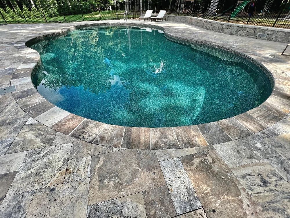 freeform pool with stone paved deck