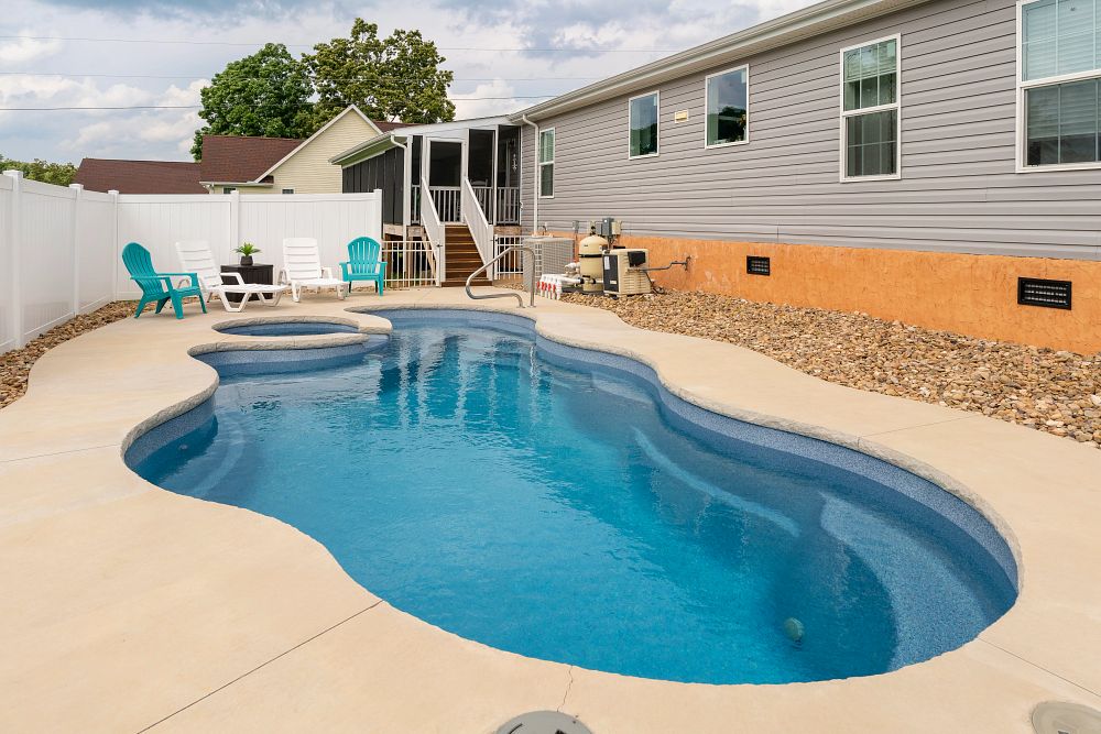 curvy fiberglass pool in a small backyard