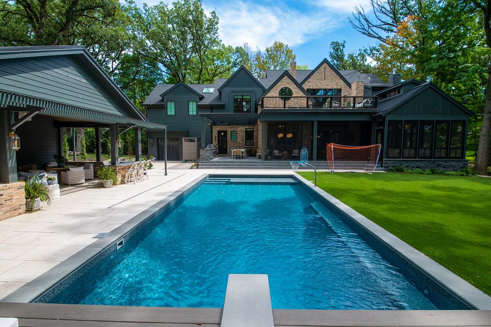 large, rectangular shaped pool in Illinois backyard with diving board and basketball hoop