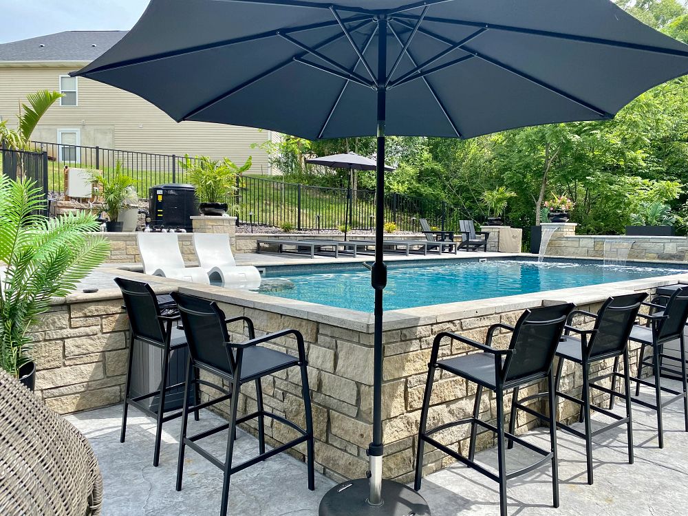 rectangular vinyl liner pool in Illinois backyard with lounge chairs and waterfall features