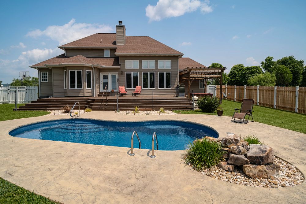 kidney-shaped fiberglass pool in large southern backyard