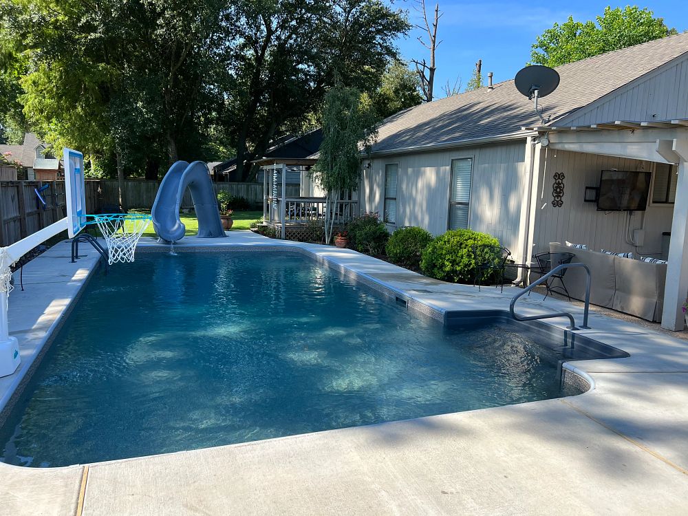 vinyl liner pool with waterslide in small southern backyard