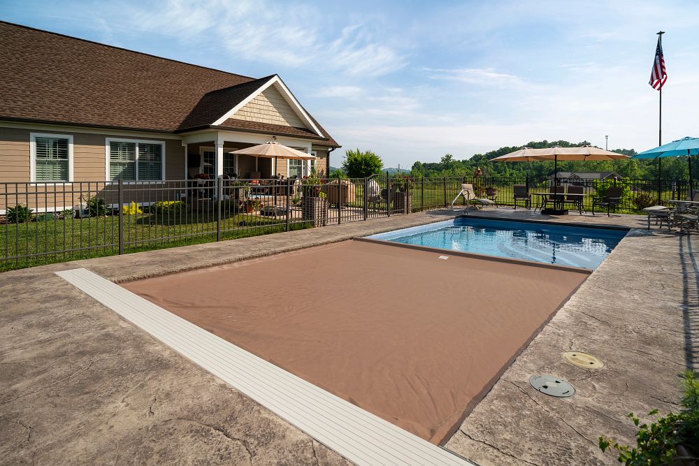 fiberglass pool with automatic cover in backyard