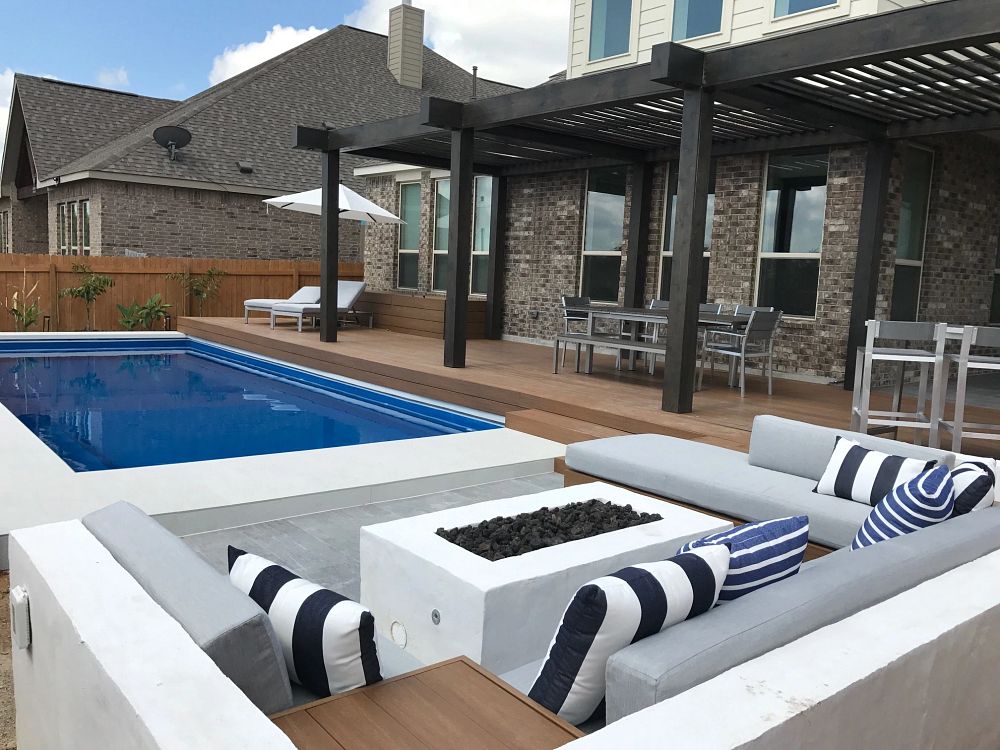 rectangle pool with modern white firepit and wraparound white couches with pillows