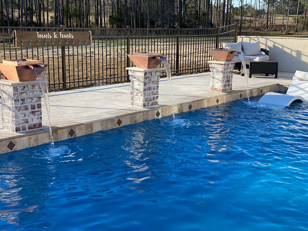 three raised fire bowls with waterfalls flowing into pool