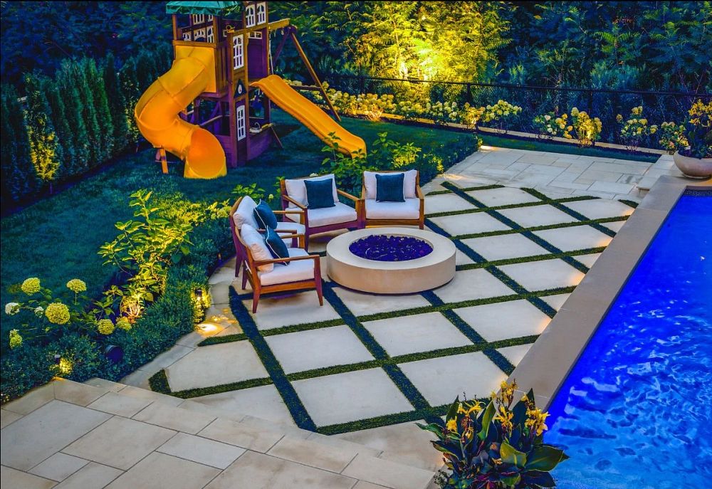 custom firepit surrounded by four patio chairs on a patio beside a rectangular pool