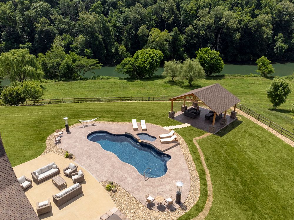 fiberglass pool with spa and water feature in large Tennessee backyard