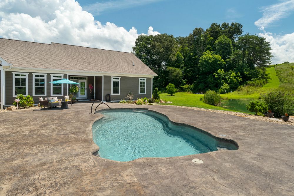 traditional freeform shaped fiberglass pool in sloped Tennessee backyard