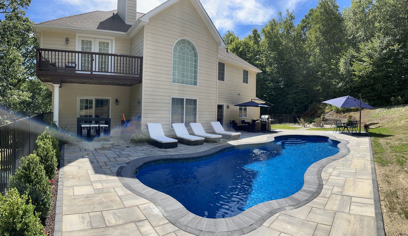 fiberglass pool installed in a sloped backyard