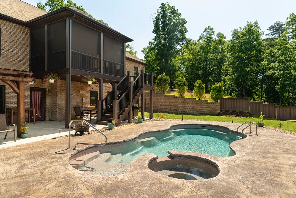 modern freeform shaped fiberglass pool with spa in Tennessee backyard
