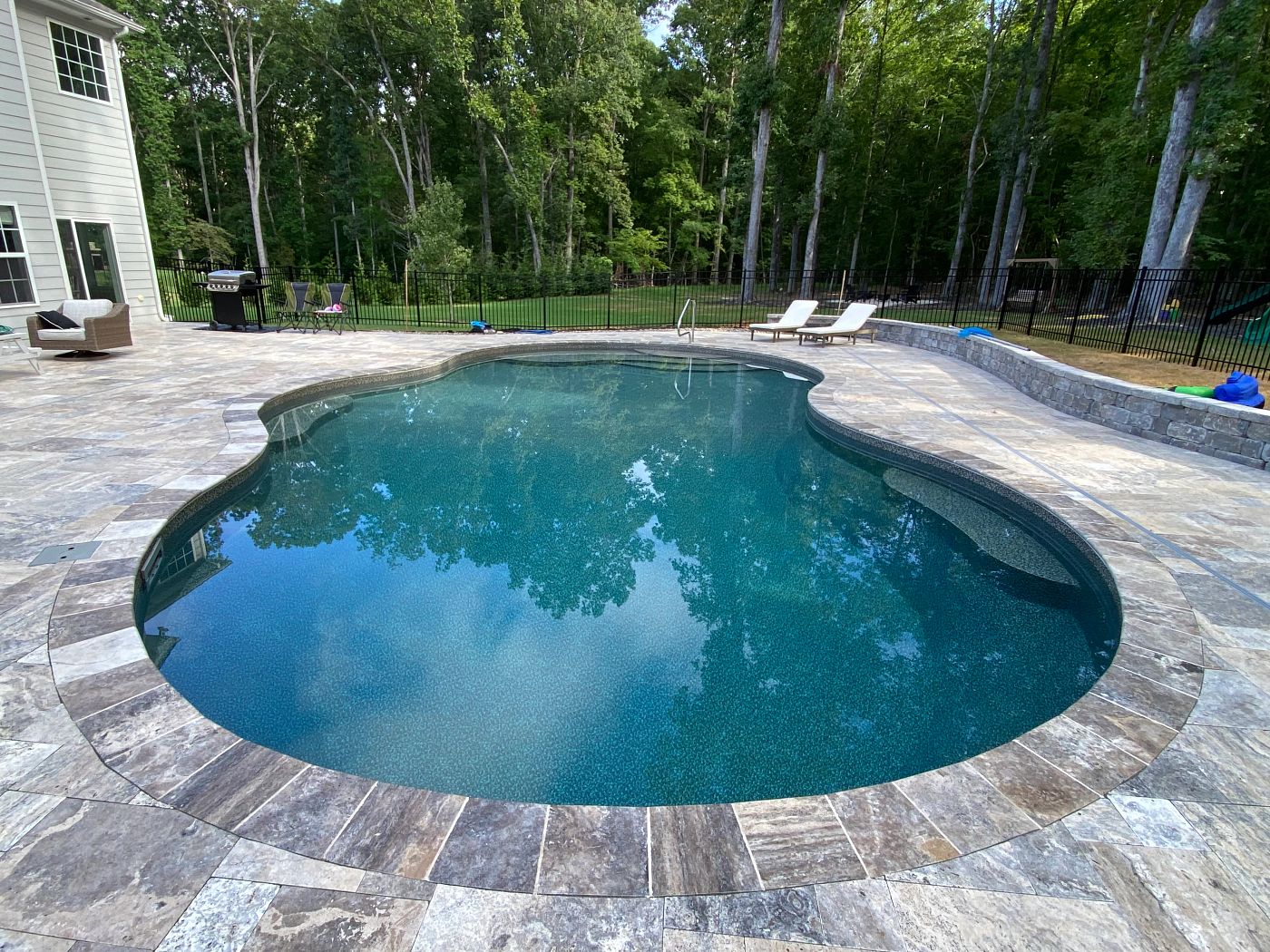 freeform vinyl liner pool in a sloped backyard