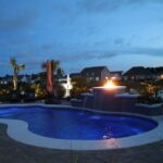 backyard pool with raised firepit