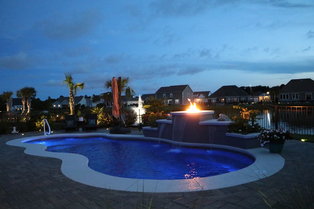 backyard pool with raised firepi