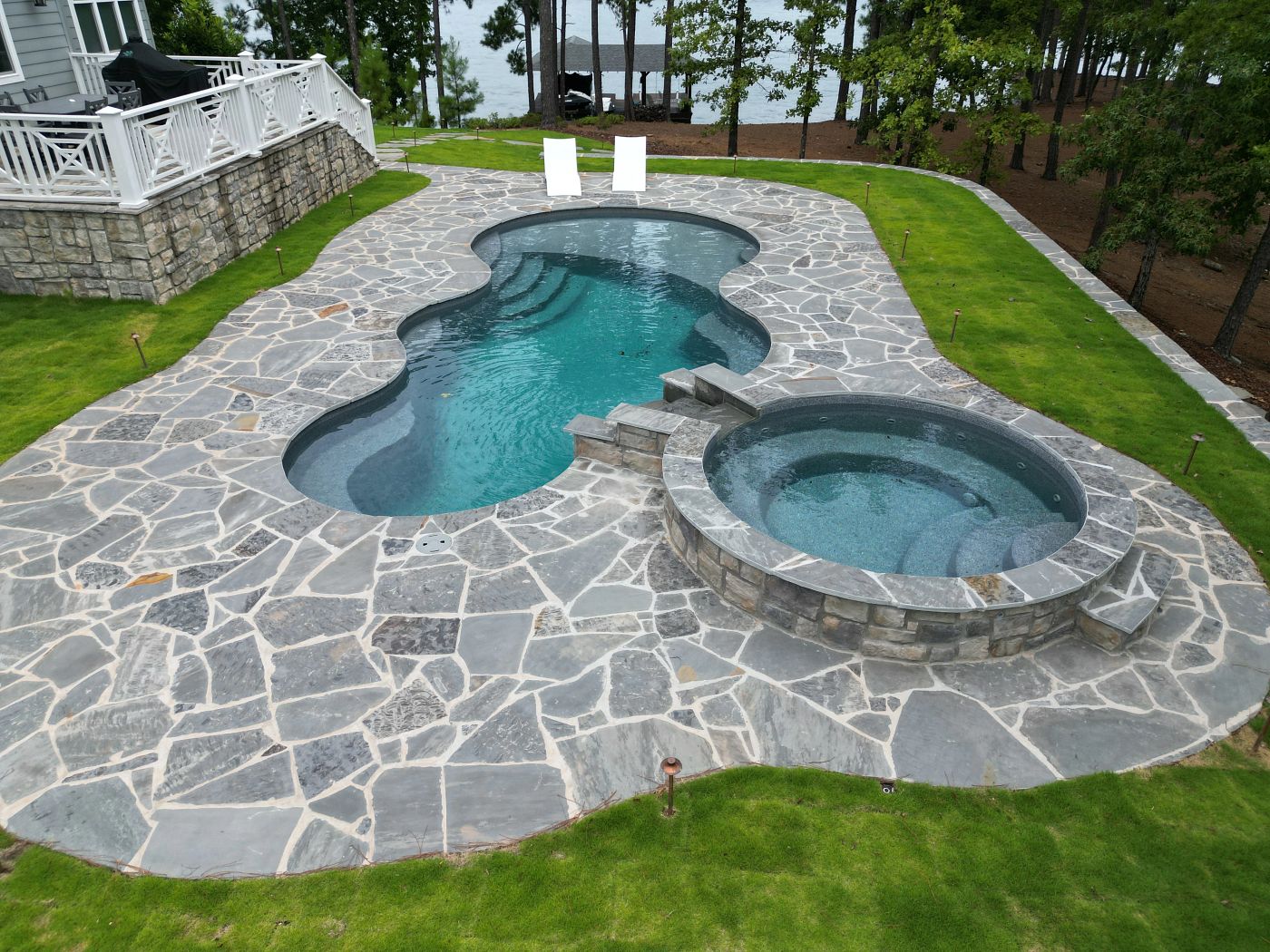 Fiberglass pool and spa with custom water feature in southern backyard.