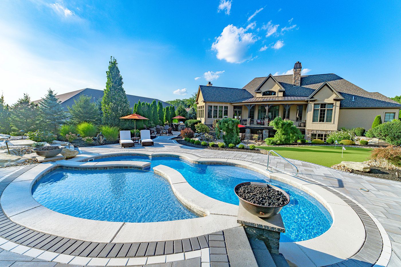 fiberglass pool with tanning ledge and firepit in large northeast backyard