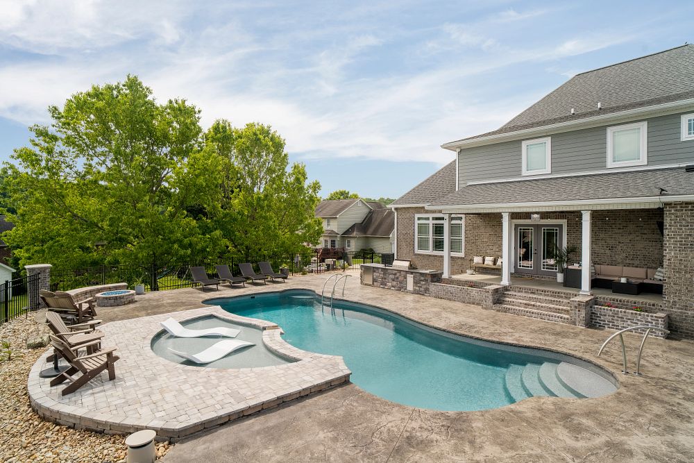 fiberglass pool with tanning ledge and firepit in southern backyard