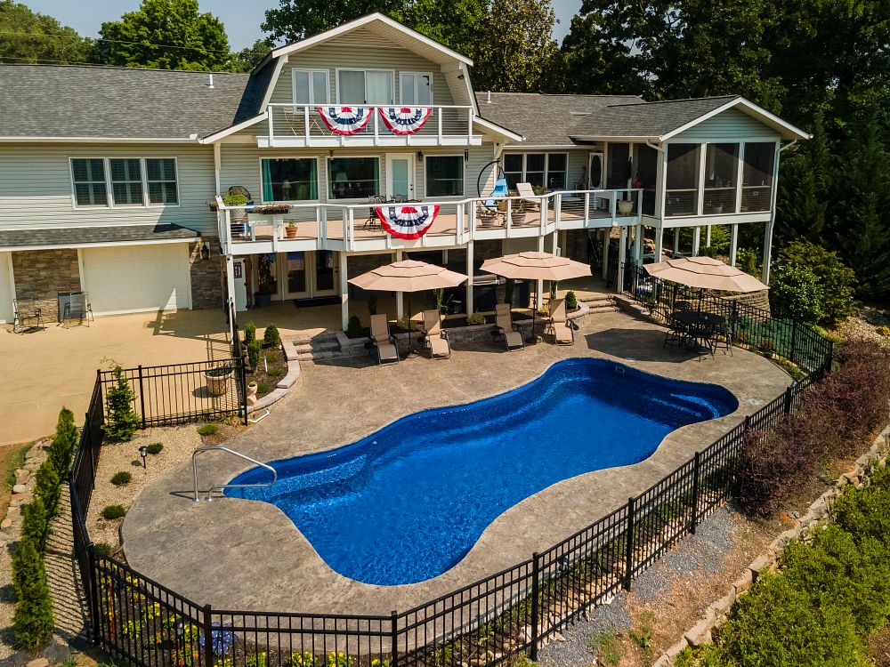 fiberglass pool in a southern backyard with safety fence