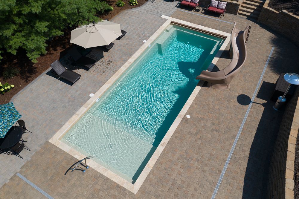 fiberglass pool with waterslide in suburban Missouri backyard