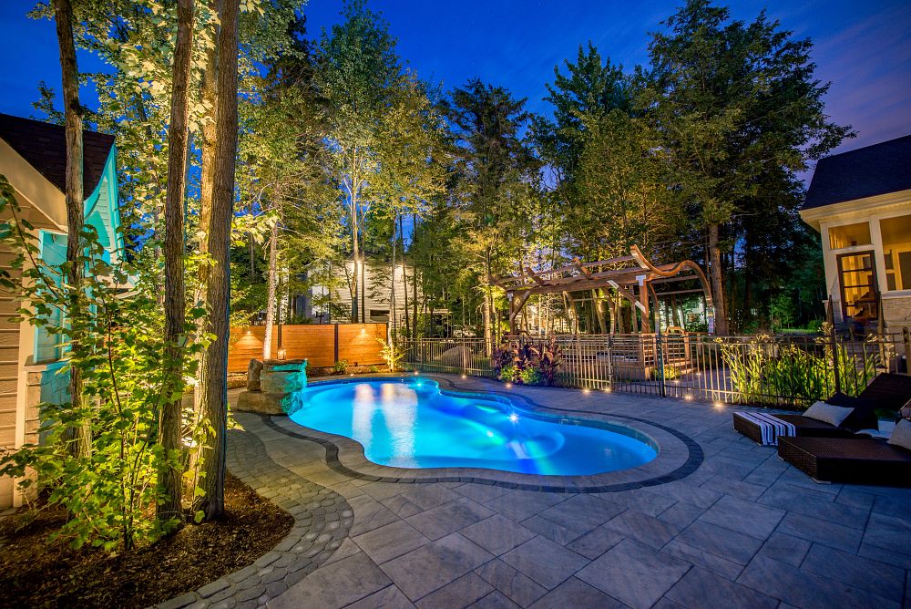 small fiberglass pool in backyard with LED lights