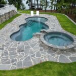 freeform fiberglass pool with spa in Alabama backyard
