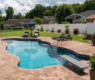 fiberglass pool with diving board built on a sloped backyard in the south