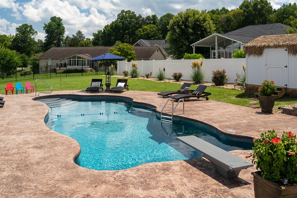 fiberglass pool with diving board built on a sloped backyard in the south