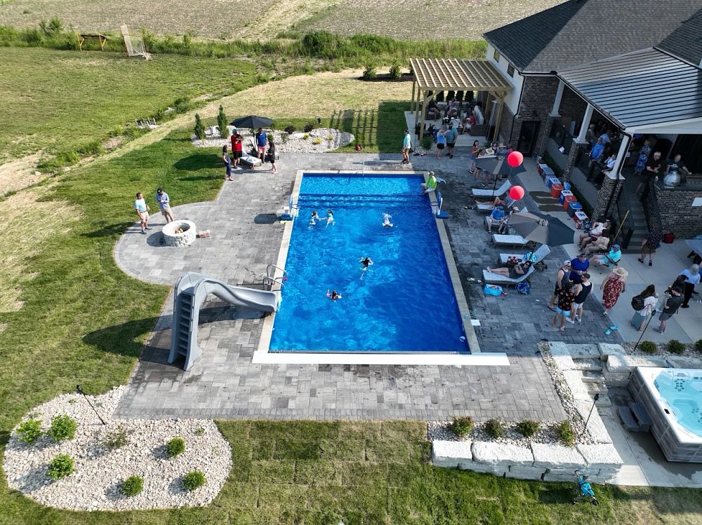 party in big backyard with kids swimming in vinyl liner pool as parents supervise