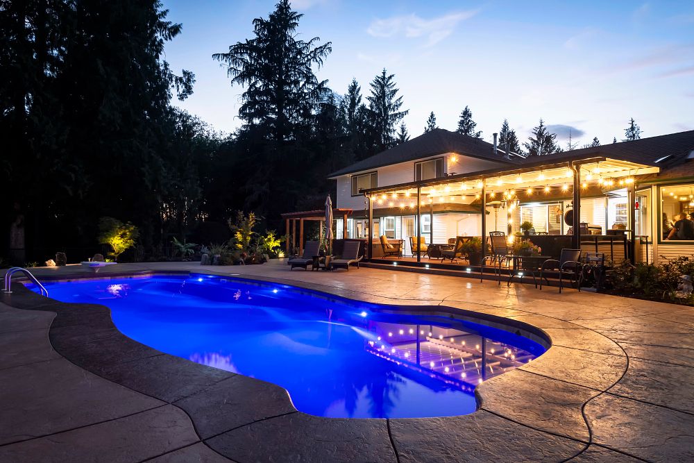 large fiberglass pool with LED lights in spacious Canadian backyard