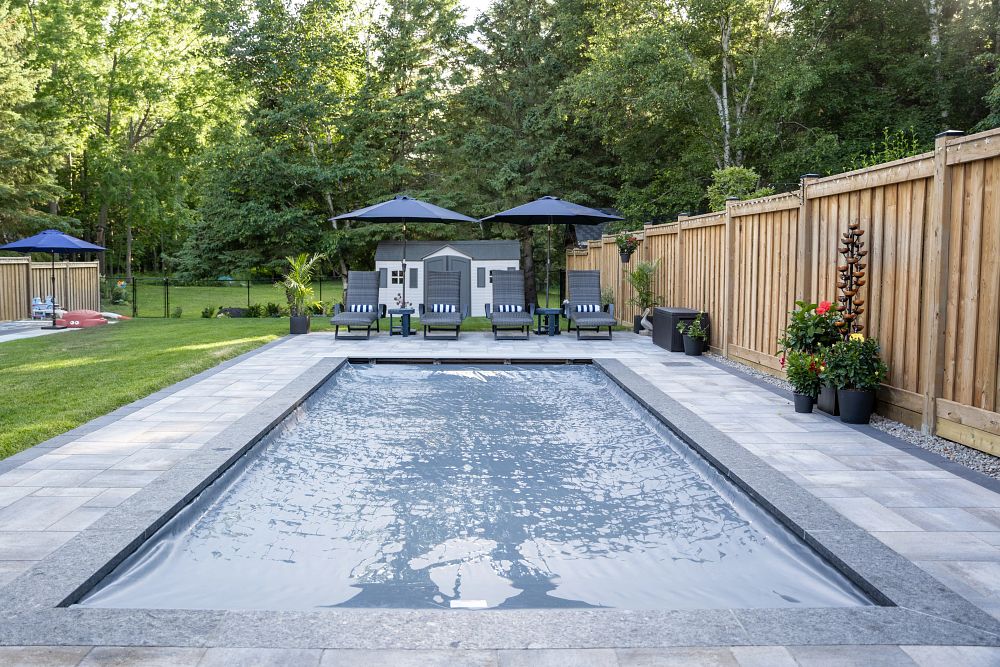 rectangular fiberglass pool in Canadian backyard with safety cover closed