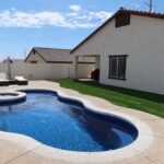 small fiberglass pool with spa in western backyard