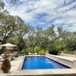 rectangular fiberglass pool with custom water features and nice landscaping