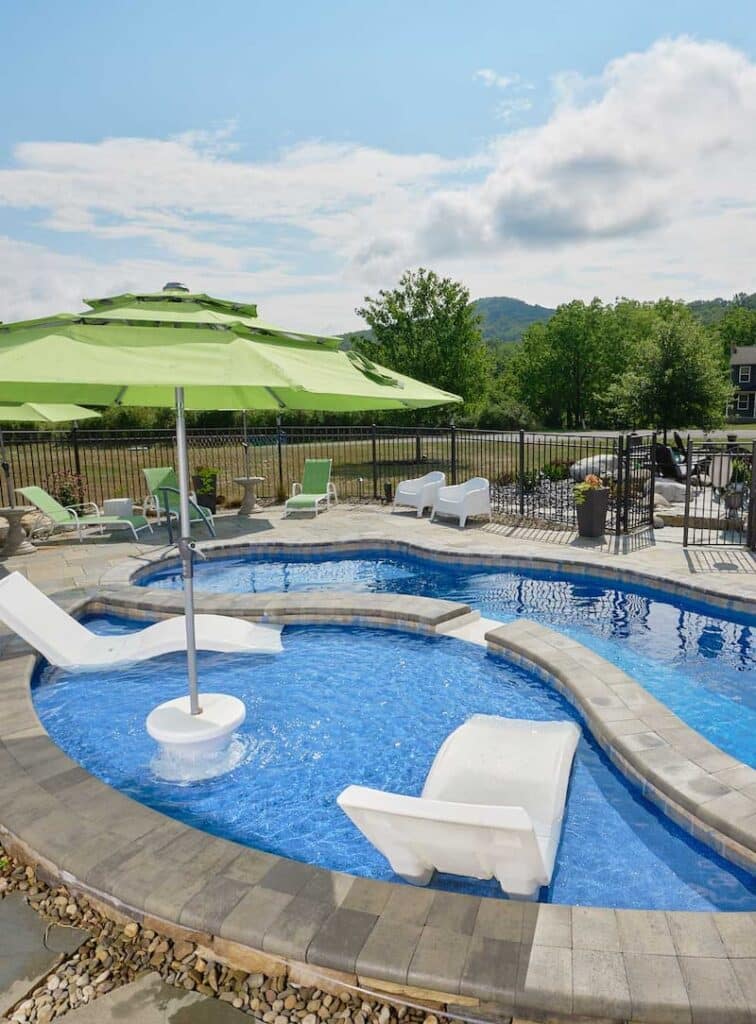 Fiberglass pool with mosaic tile design featuring a tanning ledge