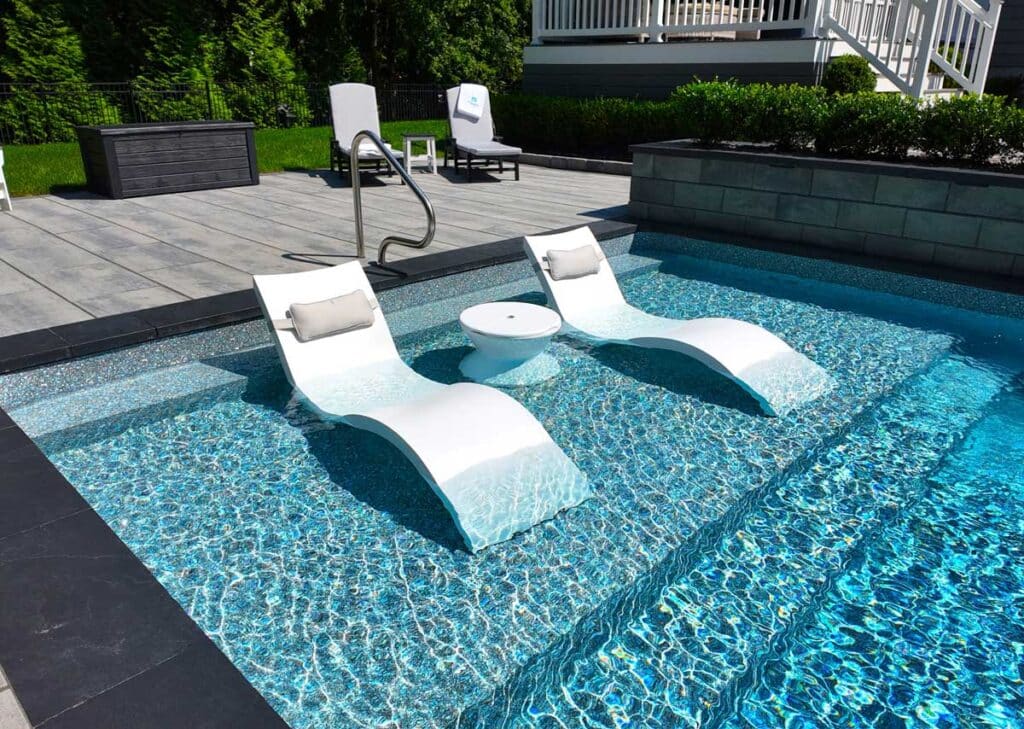 Vinyl liner pool sun ledge with built-in loungers and clear blue water in a modern Fort Lauderdale backyard