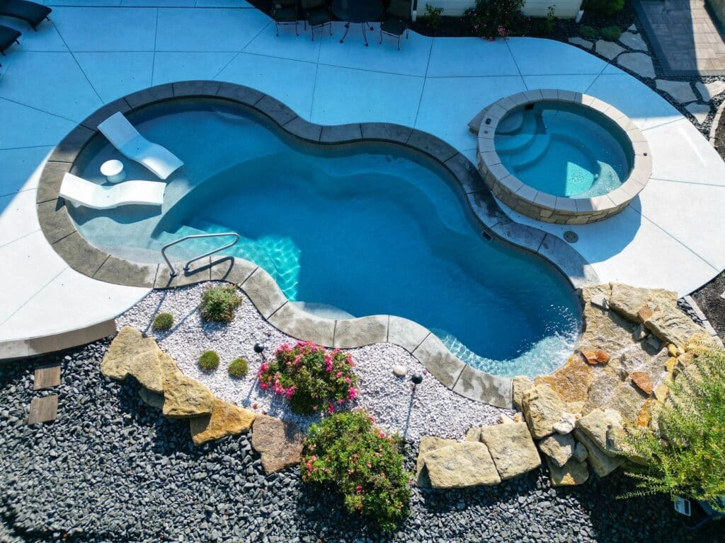 Axiom 16 fiberglass pool and elevated spa with natural stone coping and dry, desert-friendly landscaping.