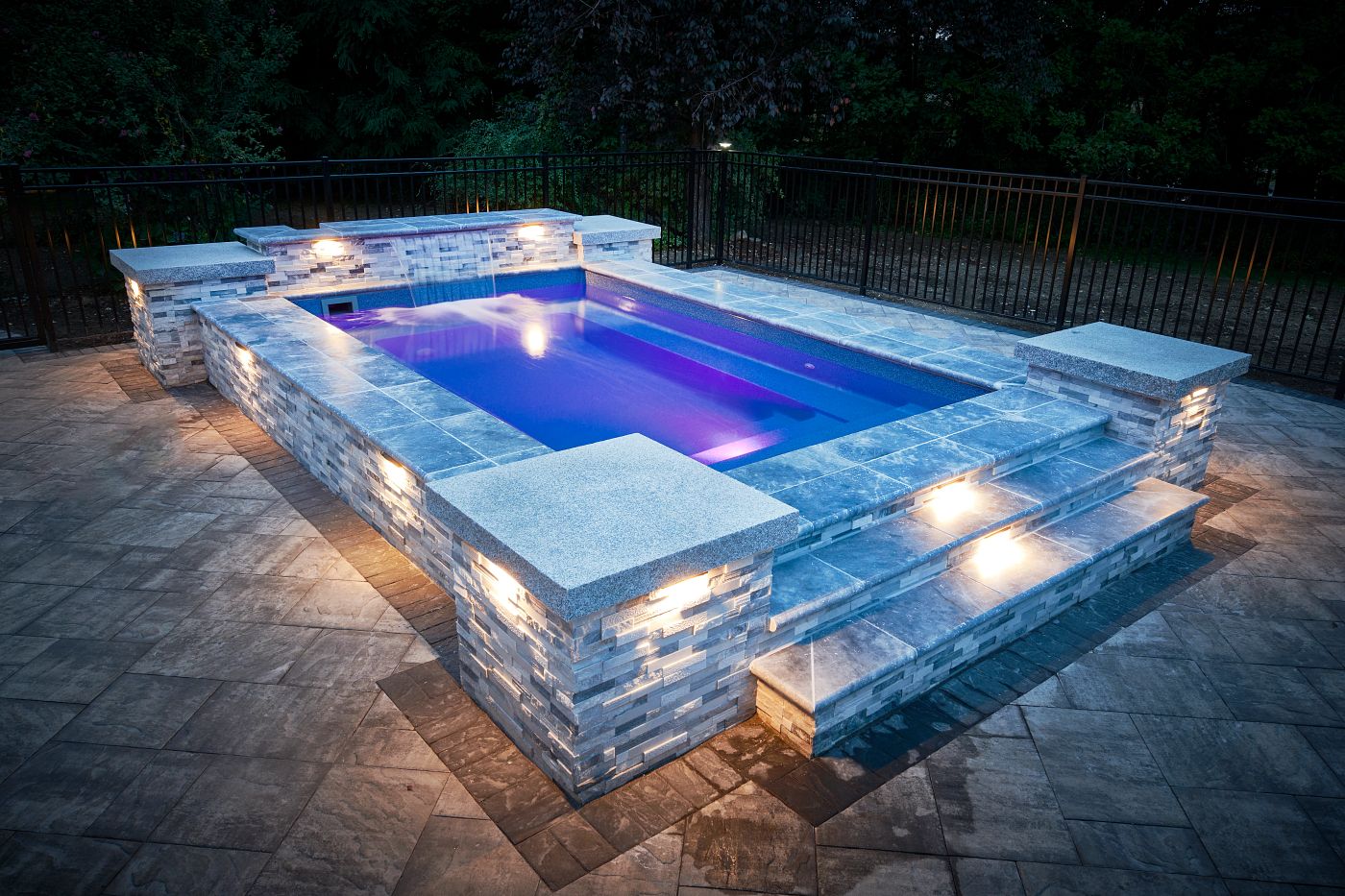 Rectangular Milan fiberglass plunge pool with sapphire blue finish, complimented by stone work and tile.