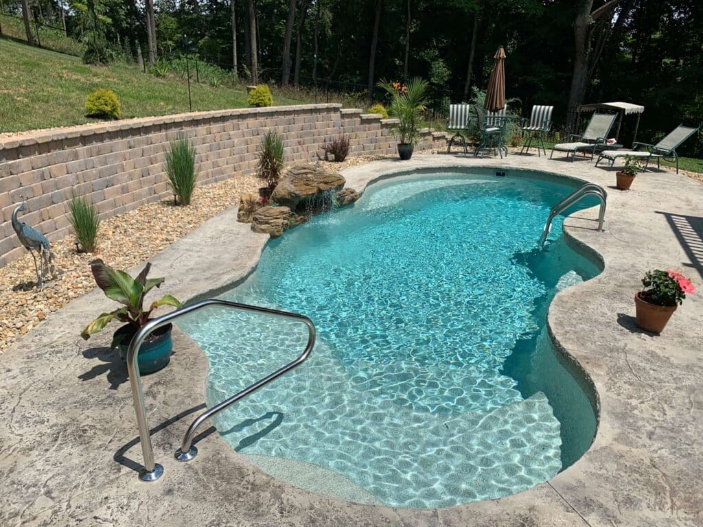 freeform inground fiberglass pool with rock waterfall