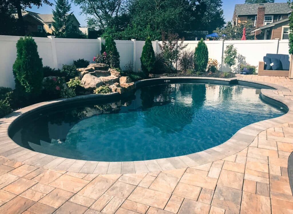 Freeform inground vinyl liner pool with rock waterfall